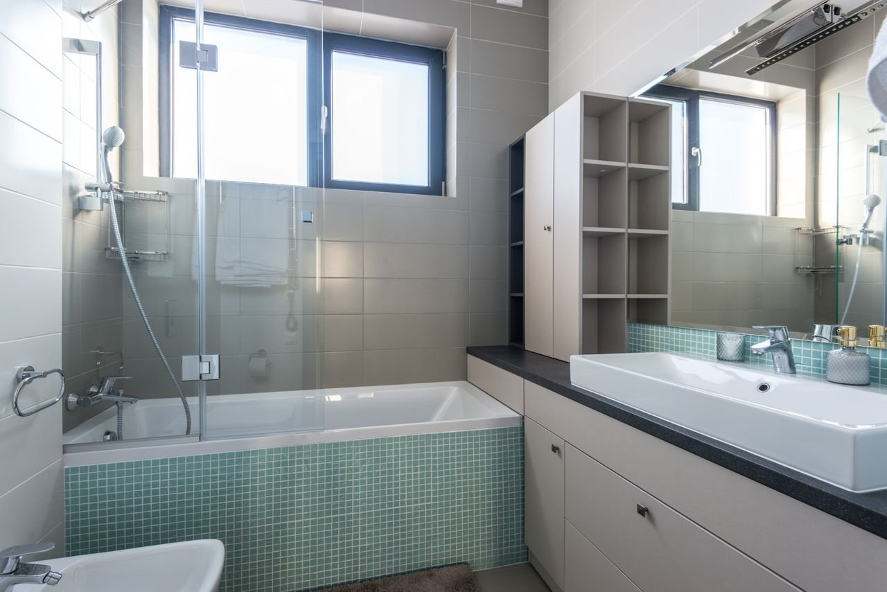 Spacious bathroom featuring a modern design with a bathtub and stylish fixtures.